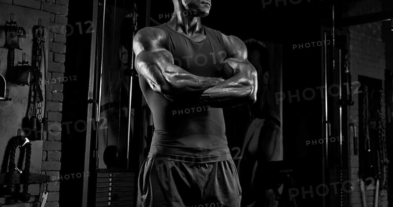 No name strong athletic man pumping up muscles
