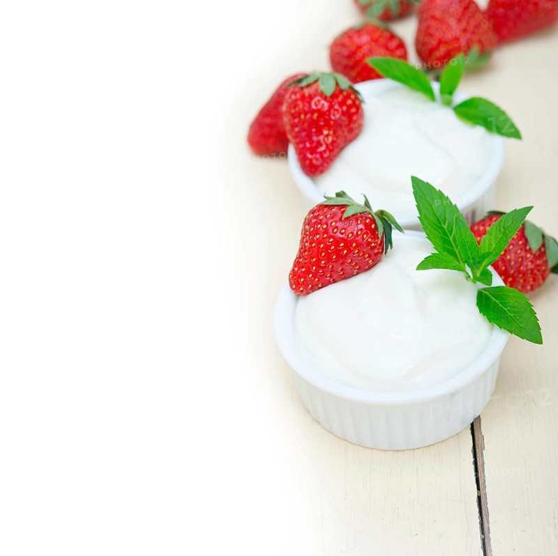 Organic Greek yogurt and strawberry over white rustic wood table