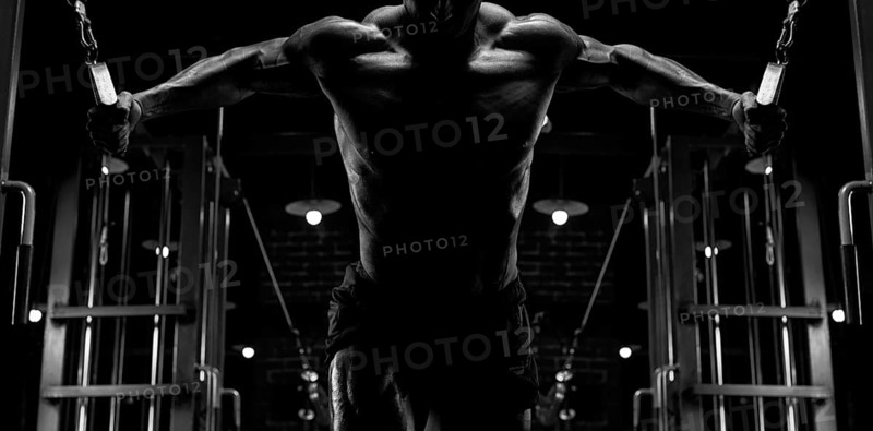 No name strong athletic man pumping up muscles