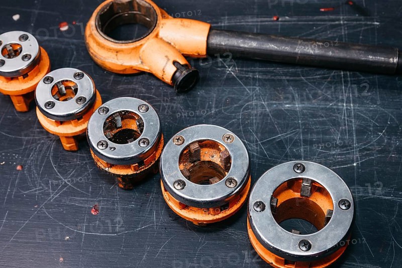 Professional tool for plumber locksmith for threading sewer metal and plastic pipes. A set of klups
