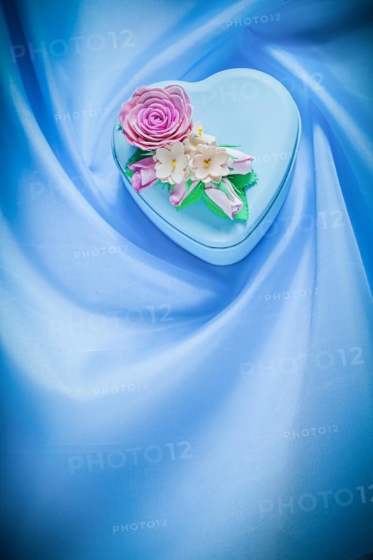 Heart-shaped gift box on blue fabric background celebrations concept