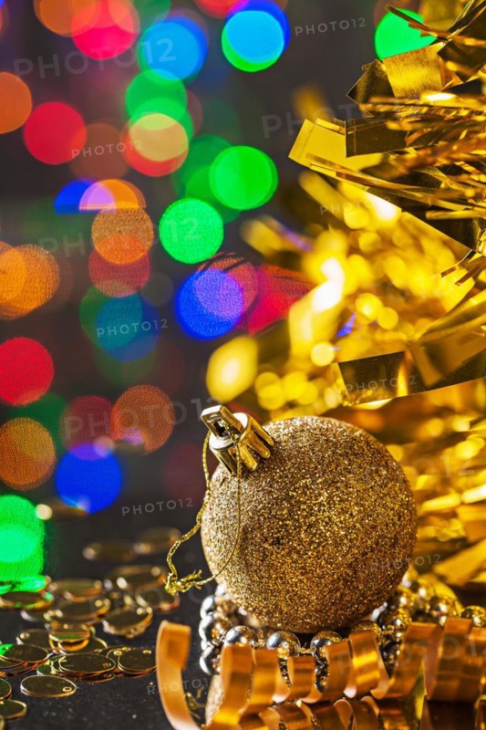 Gold Christmas bauble on the background of dark bokeh