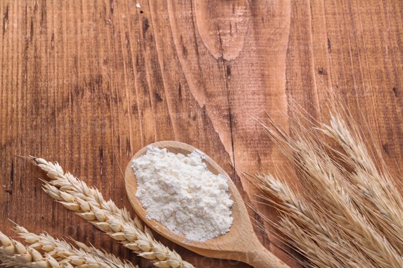 Copyspace image white natural flour in spoon and ears of wheat and rye on vintage wooden board