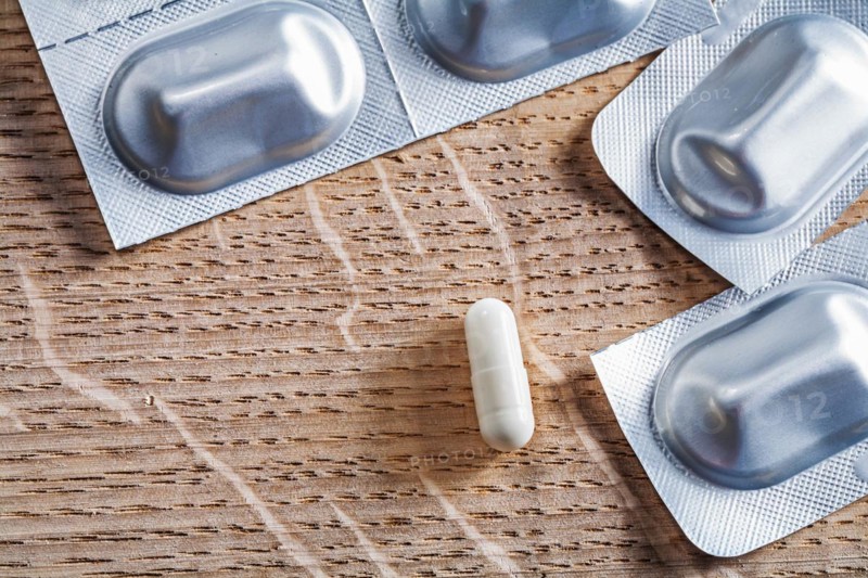 Pills on an old wooden board