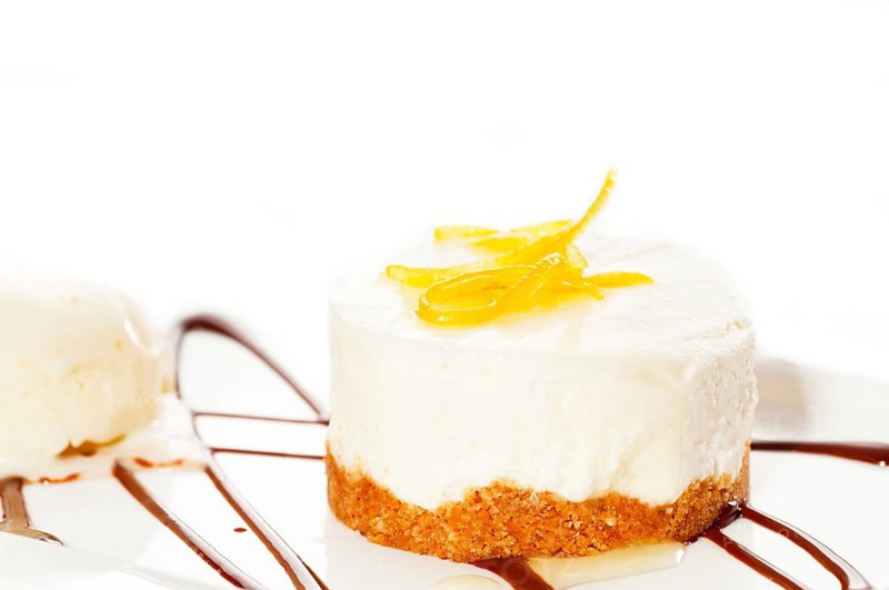 Very elegant lemon mousse dessert served whith lemon peel on top and vanilla ice cream on side