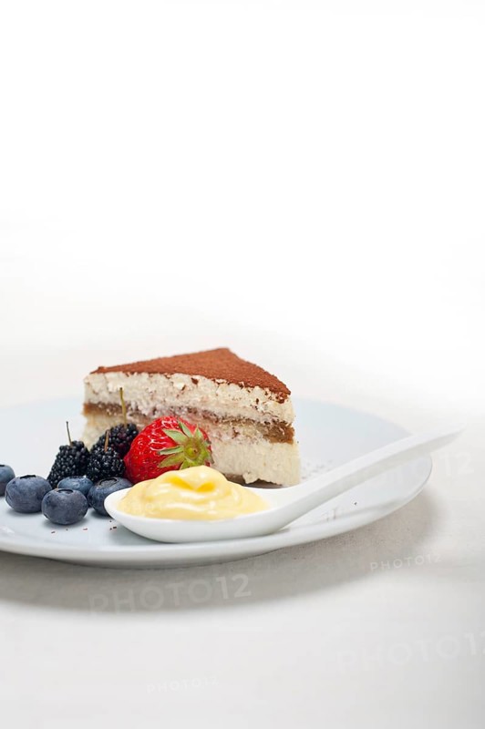 Classic Italian tiramisu dessert with berries and custartd pastry cream on side