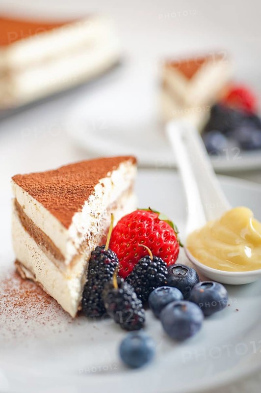 Classic Italian tiramisu dessert with berries and custartd pastry cream on side