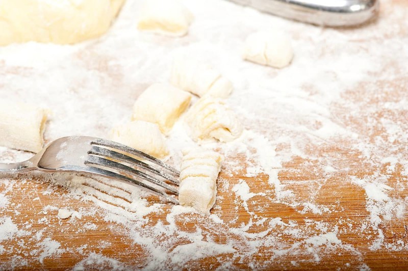 Making fresh Italian potato gnocchi on a wood rustic table