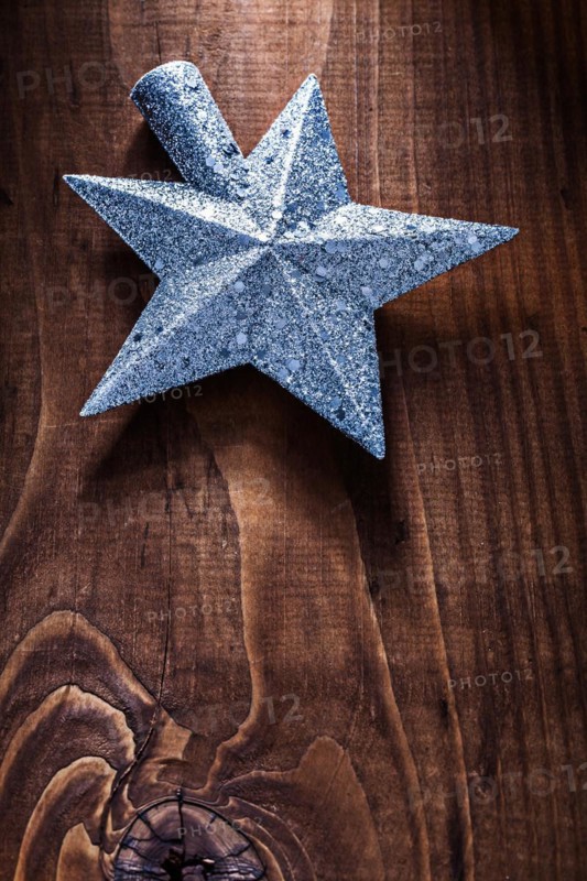 Christmas toy star for Christmas tree on old wooden background