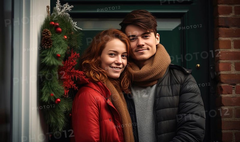 Young couple smiling together near home door decorated with mistletoe. Christmas holidays Ai generated