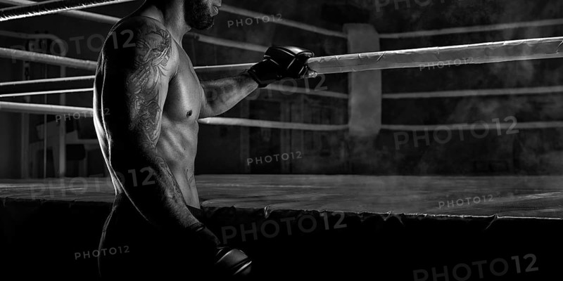 Kickboxer holding on to the ring rope. Sports competitions. Fight night. The concept of mixed martial arts. MMA