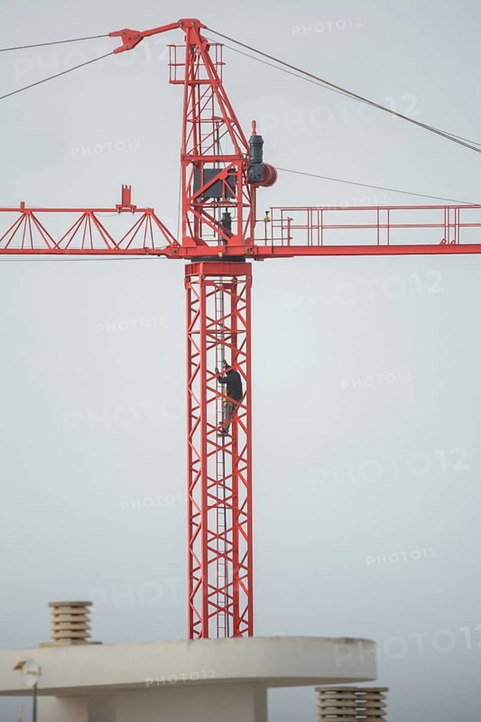Professional crane operator inspecting the crane at high altitude