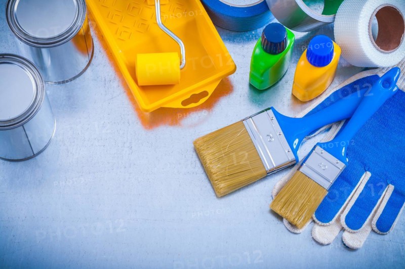 Household tapes protective gloves and paint tools on metallic background construction concept