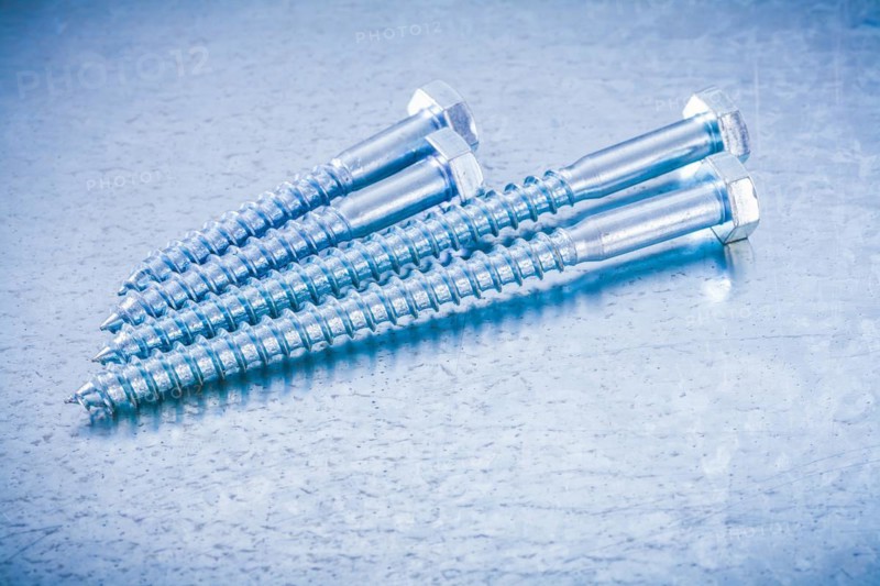 Composition of metal threaded bolts on a metallic background Design concept