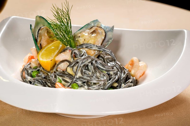 Fresh seafood black squid ink coulored spaghetti pasta tipycal italian food