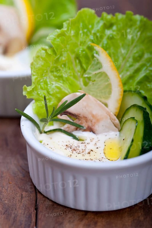 Fresh organic garlic cheese dip salad on a rustic table