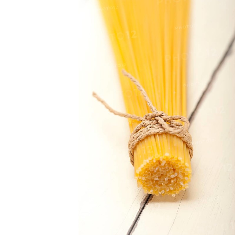 Italian pasta spaghetti tied with a rope on a rustic table