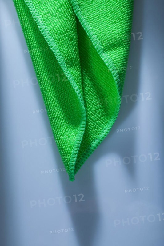 Green kitchen dishwashing cloth on white background