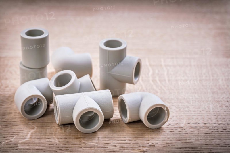 Set of polypropylene pipe fittings on wooden board