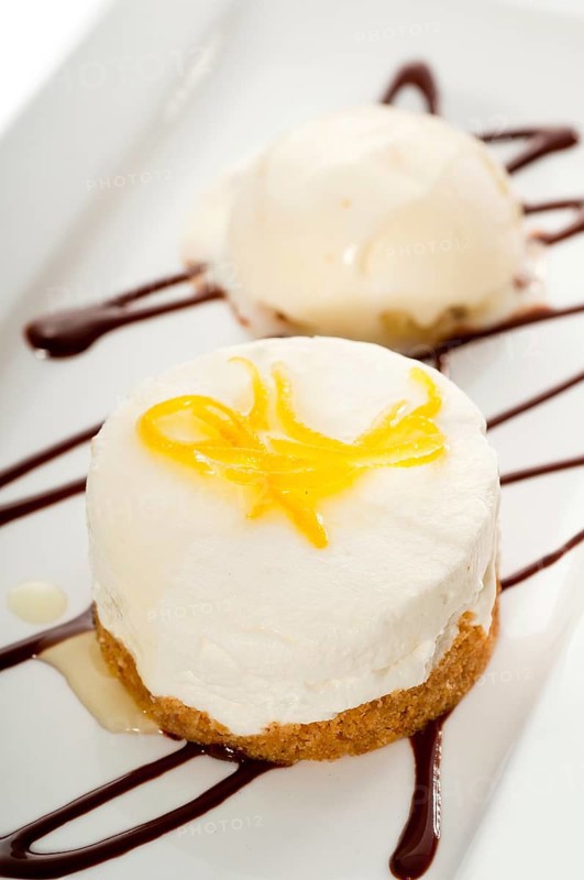 Very elegant lemon mousse dessert served whith lemon peel on top and vanilla ice cream on side