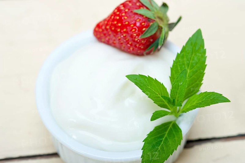 Organic Greek yogurt and strawberry over white rustic wood table