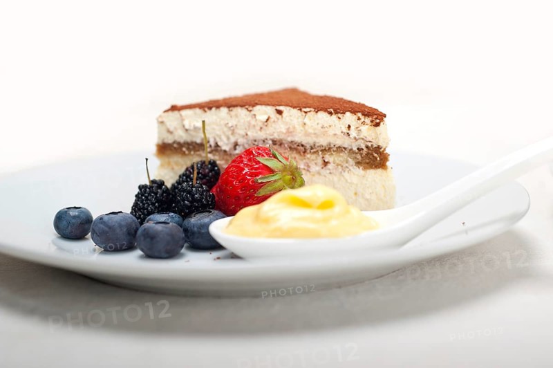 Classic Italian tiramisu dessert with berries and custartd pastry cream on side