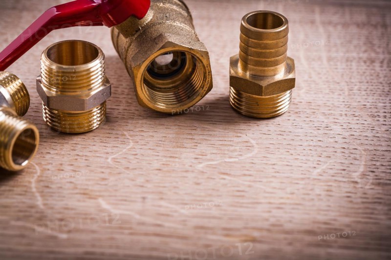 Plumbing tools Brass pipe connector on wooden board Close Up