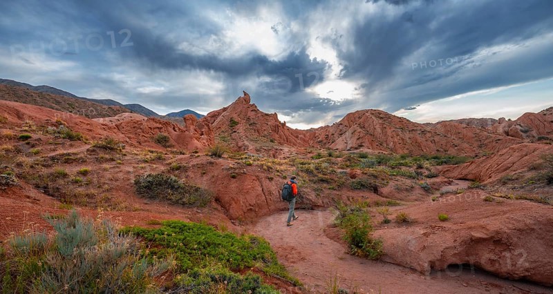 Tourist hikes through canyon of eroded sandstone formations