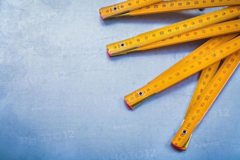 Copy space image of wooden metre on metallic background construction concept