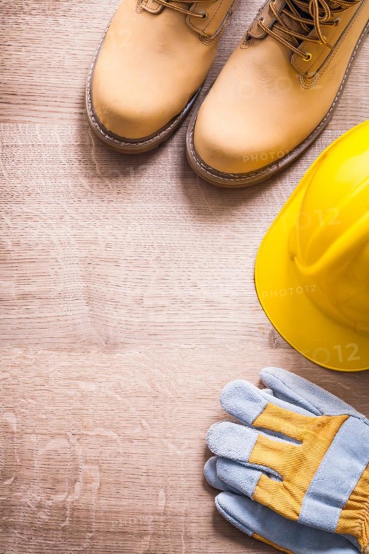 Organised copyspace working boots helmet gloves On Wooden Board