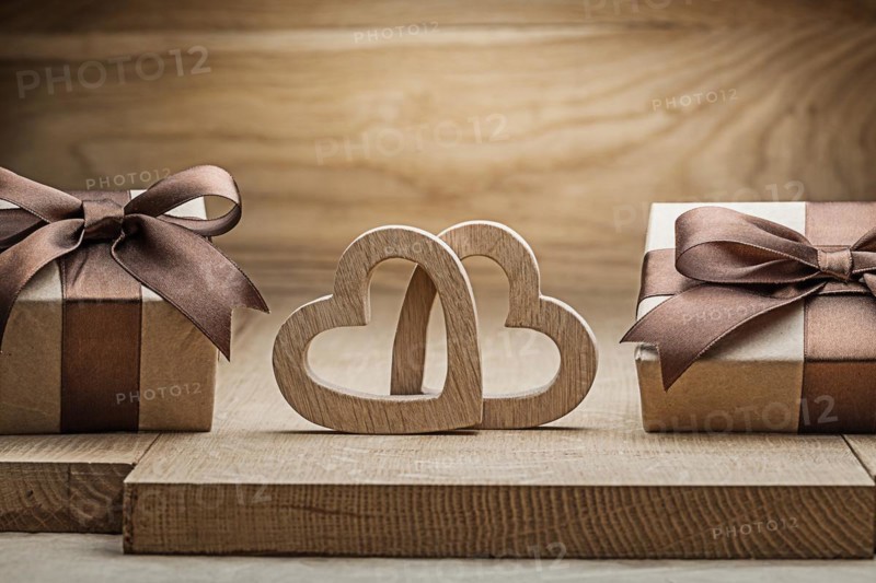Close up view vintage wood hearts and gift boxes on wooden background