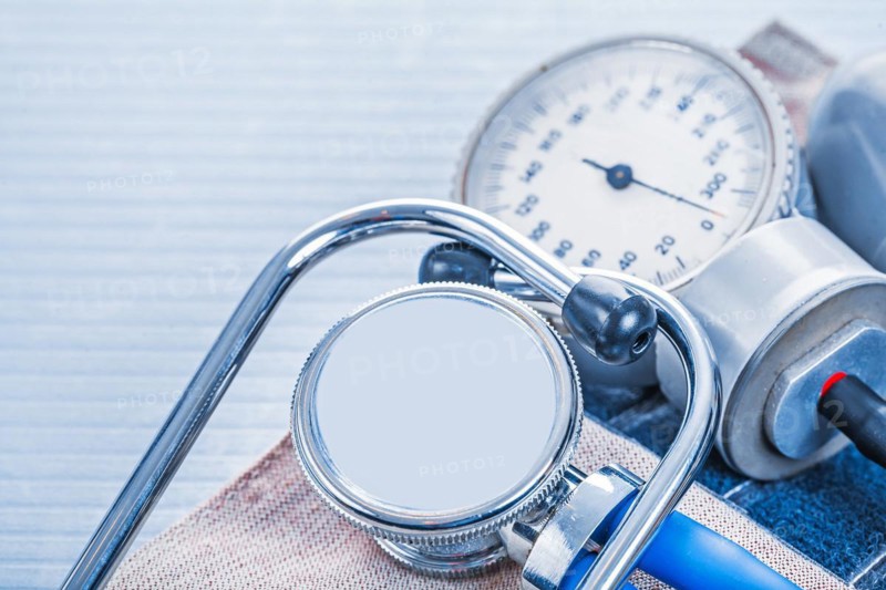 Stethoscope on blood pressure monitor on blue background medical concept