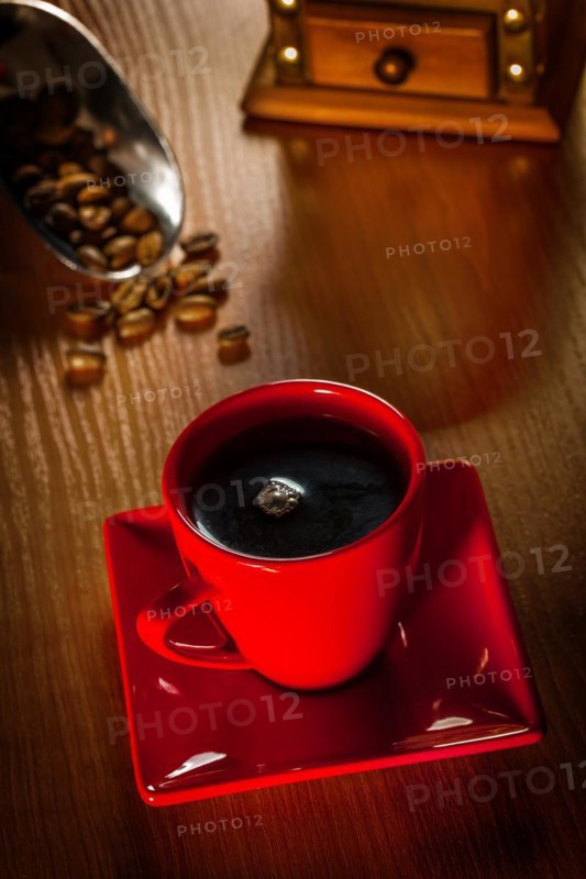 Coffee in a red cup on a wooden board