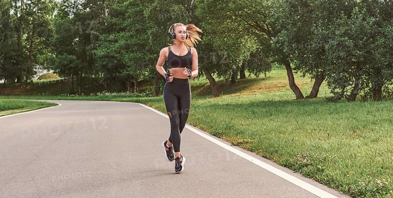 Fitness girl in sportswear runs through the evening sunny park. Healthy lifestyle. Mixed media