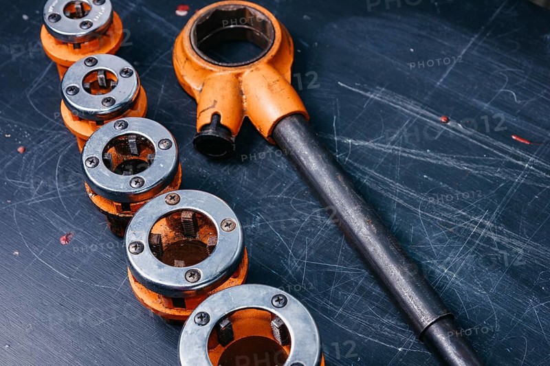 Professional tool for plumber locksmith for threading sewer metal and plastic pipes. A set of klups