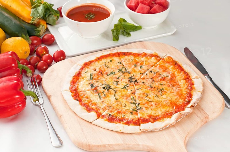 Italian original thin crust pizza Margherita with gazpacho soup and watermelon on side