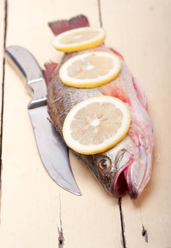 Fresh whole raw fish on a wooden table ready to cook