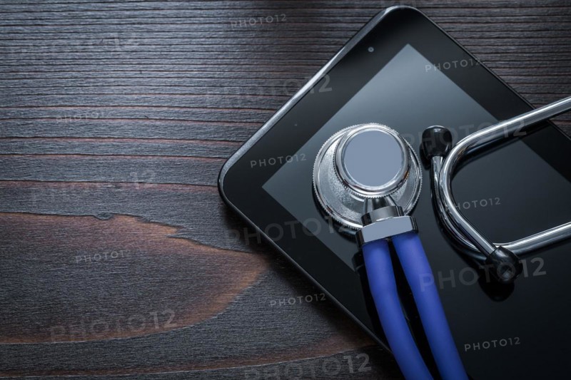 Horizontal version of stethoscope and tablet on vintage wooden background medicine concept