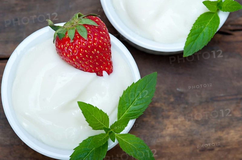 Organic Greek yogurt and strawberry on a rustic wood table