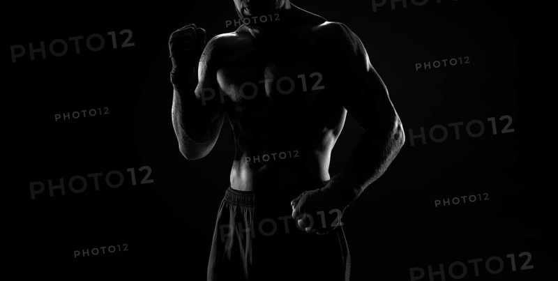 Noname image of a kickboxer on a dark background. The concept of mixed martial arts. MMA