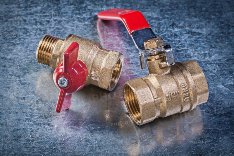 Brass gate lever ball valve on scratched metallic background plumbing concept