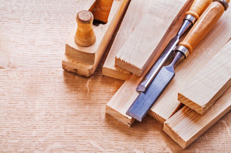 Chisel on boards and wooden plane on wooden board