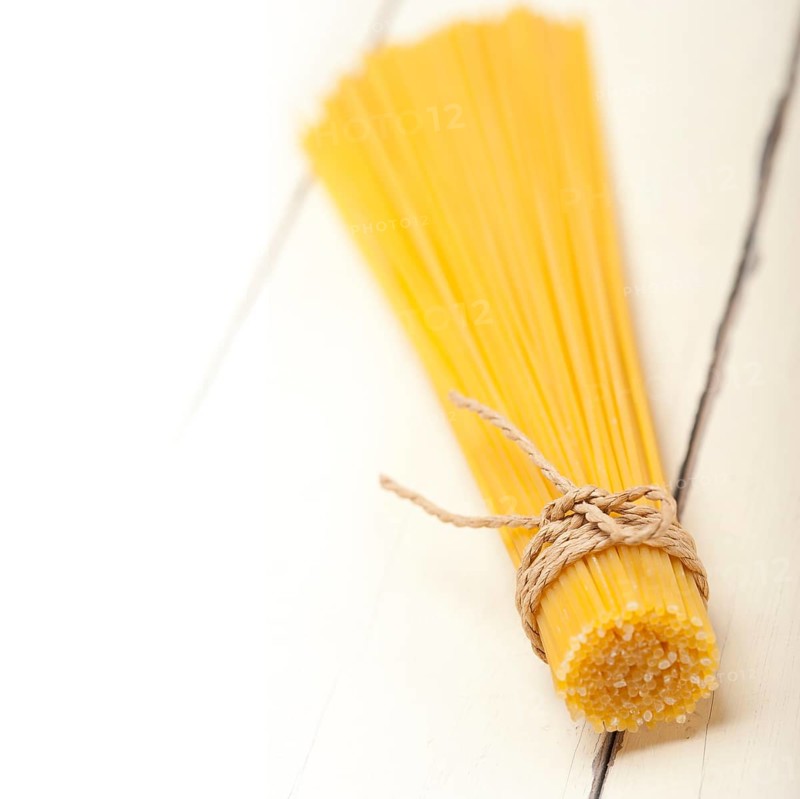Italian pasta spaghetti tied with a rope on a rustic table