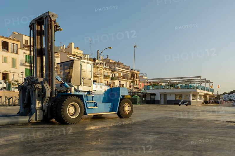 Forklift lowers a boat into the water at a marina