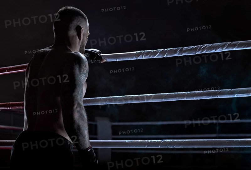 Kickboxer climbs into the ring. View from the back. Sports competitions. Fight night. The concept of mixed martial arts. MMA
