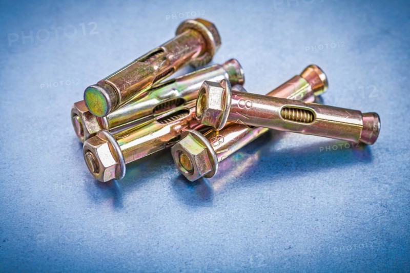 Set of metal anchor bolts for concrete walls on metallic background Construction concept
