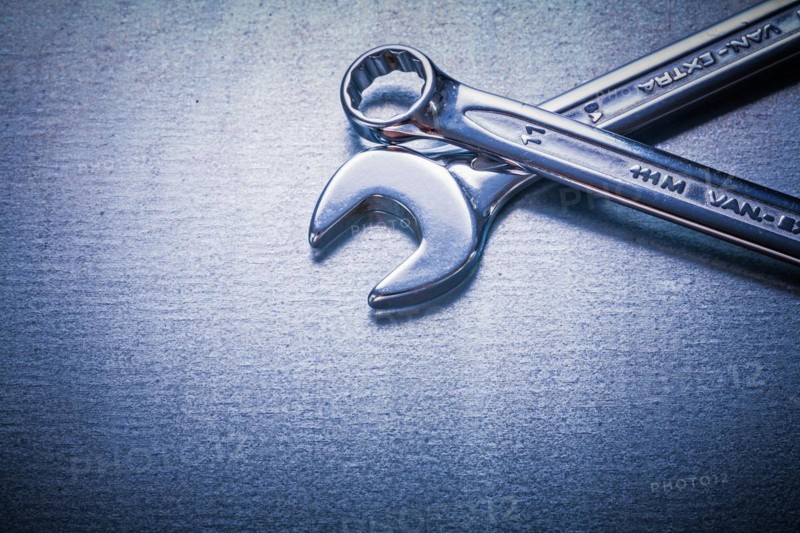 Flat spanner and hook spanner on a metallic background Design concept