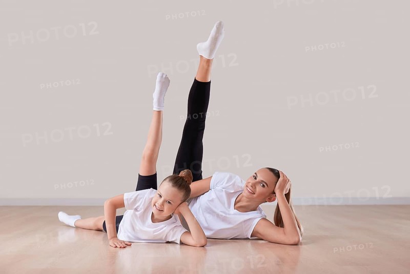 Beautiful female teacher poses with a little girl in a gymnastics class. The concept of education