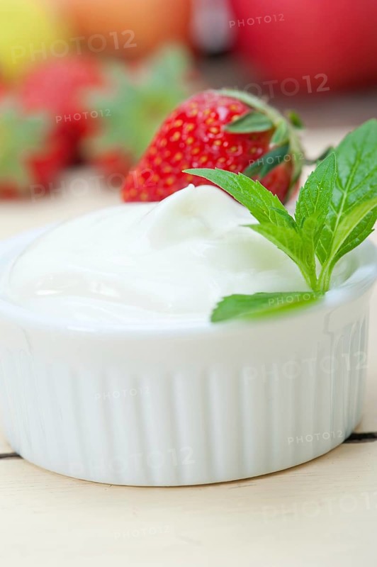 Organic Greek yogurt and strawberry over white rustic wood table