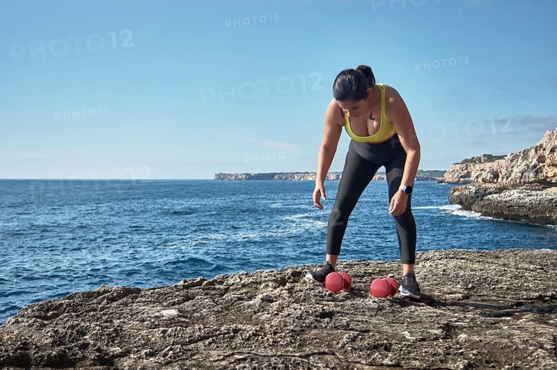 FITNESS LATIN WOMAN IN SPORTS SET TRAINING WITH ELASTIC BAND